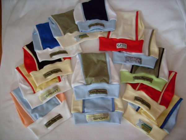 Kolekcja czapek i chustek wielokolorowych z naszywkami, ułożonych na białym tle, prezentujących różne wzory i style, w tym 'Cool Rotation', 'Speed Sport' i 'Technical Division'.